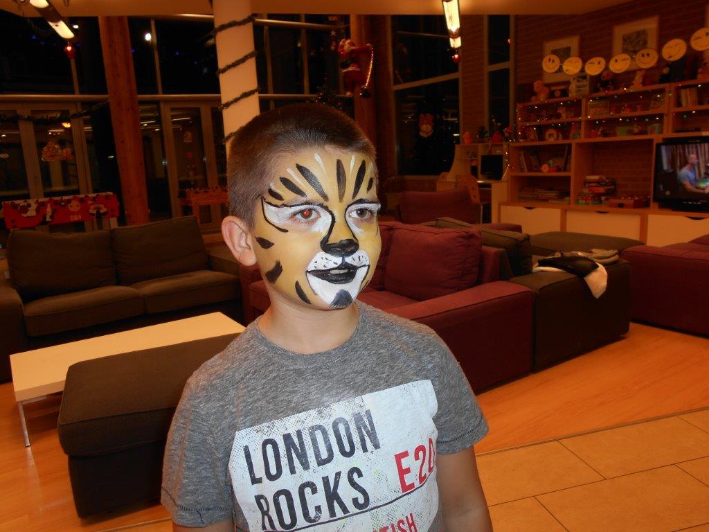 A kisfiú arcát tigrisre festették ki.